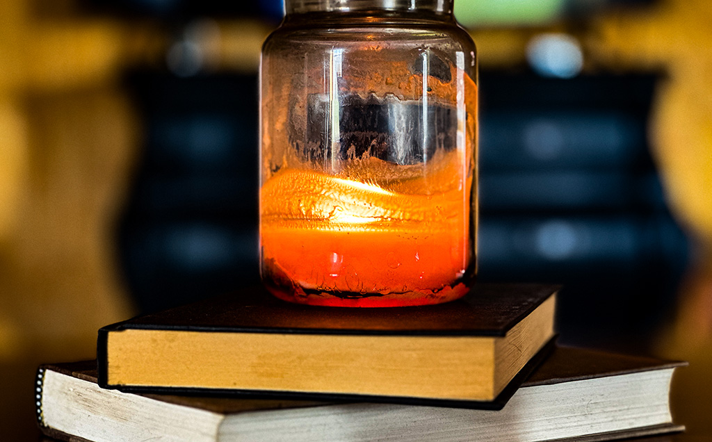 lit candle resting on books